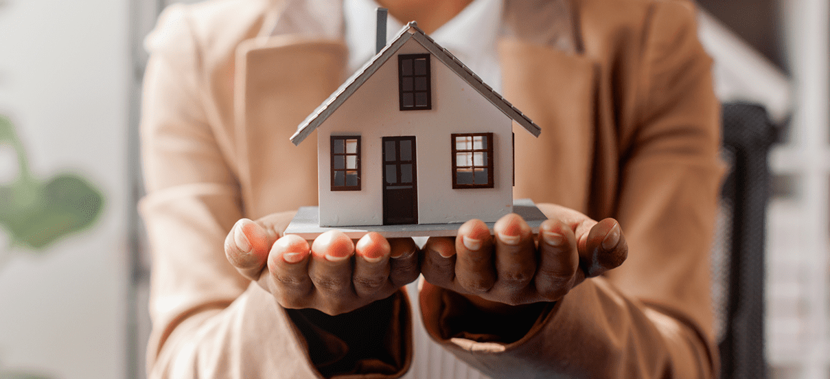 Person holding model house
